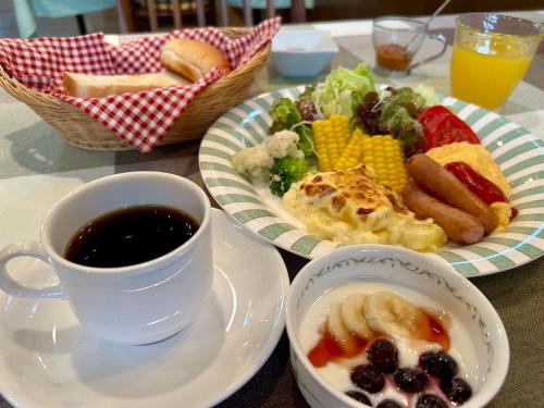 a table with two plates of food and a cup of coffee at マウンテンリゾート・マルガンタ Marganta in Madarao Kogen