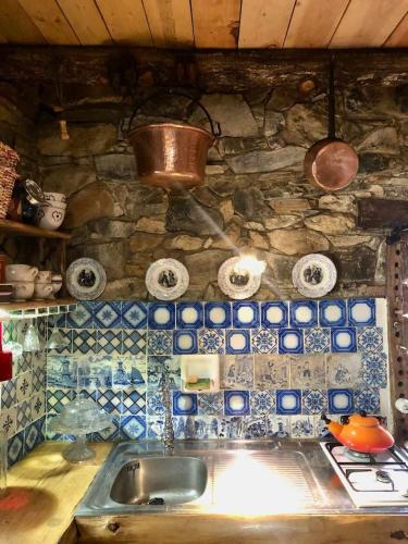a kitchen with a sink and a stone wall at Insolite bergerie dans la forêt in Arnac-sur-Dourdou