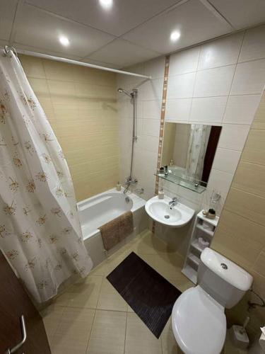 a bathroom with a toilet and a sink and a tub at large apartment in Borovets in Borovets