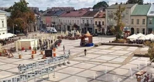 a city square with a person walking in the street at Nowy Paris in Kielce