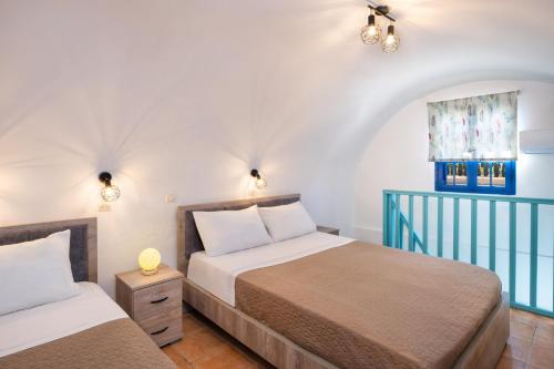 a bedroom with two beds and a window at Georgia's Comfort Studio in Perivolos