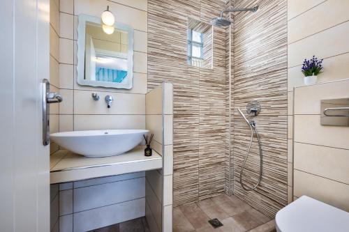 a bathroom with a sink and a shower at Georgia's Comfort Studio in Perivolos