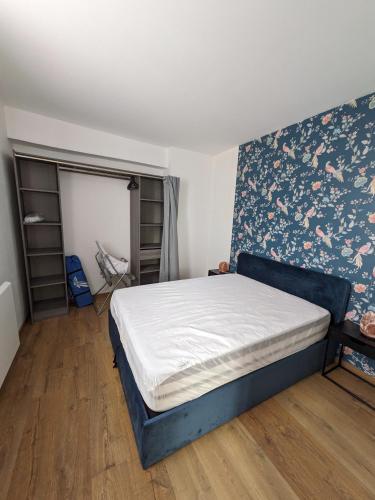 - une chambre avec un lit orné d'un mur fleuri dans l'établissement Appartement cosy - centre-ville, à Boulogne-sur-Mer