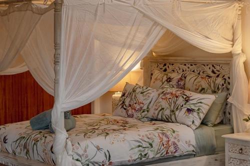 a bedroom with a bed with a canopy at Bluelake Cottage Metung in Metung
