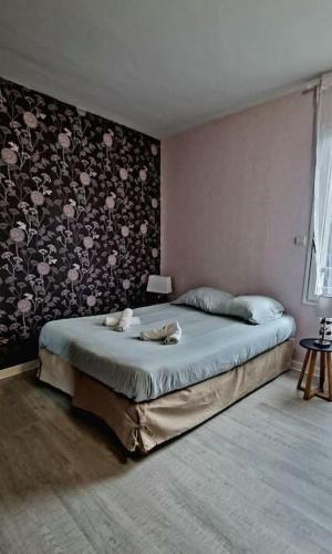 - une chambre avec un lit orné d'un mur fleuri dans l'établissement Bel Appartement et Jardin hyper Centre de Dol, à Dol-de-Bretagne