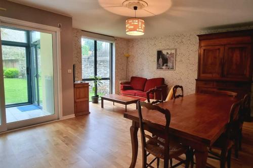 un salon avec une table et un canapé rouge dans l'établissement Bel Appartement et Jardin hyper Centre de Dol, à Dol-de-Bretagne