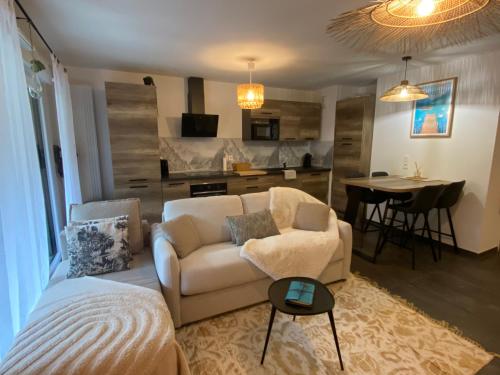 a living room with a couch and a dining room at T3, à 5 min à pied du lac Annecy in Duingt