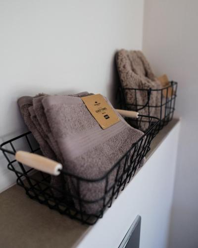 two towels in a basket on a wall at 99 Maison by Noire - Deluxe Bungalow Sibiu -Adults Only in Sibiu