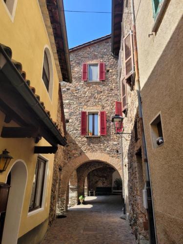 an alley in an old stone building with red windows at Villetta Poesia in Morcote