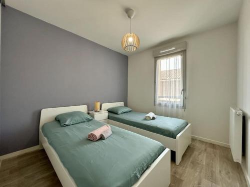 une chambre avec deux lits et une fenêtre dans l'établissement spacieux T3 calme et lumineux, à Carcans