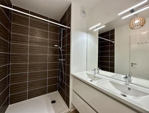 une salle de bain avec un lavabo et un miroir dans l'établissement spacieux T3 calme et lumineux, à Carcans