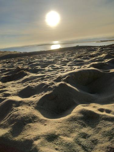 une plage de sable avec un coucher de soleil en arrière-plan dans l'établissement la réserve, à Gastes