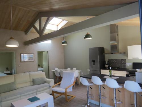 a living room with a couch and a table and chairs at La Belle Insulaire, Vertbois plage, forêt, vélos, wifi in Dolus d'Oléron