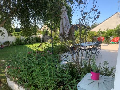un jardin avec une table et un parasol dans l'établissement Havre de Paix, à Champagne-sur-Seine