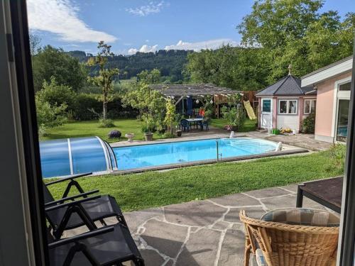 a view of a swimming pool from a house at Schöne Wohnung mit Terrasse, Garten und-Pool in Thalgau