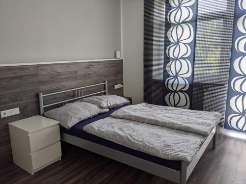 a bedroom with a bed with a wooden headboard at Schöne Wohnung mit Terrasse, Garten und-Pool in Thalgau