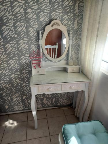 a dressing table with a mirror on a wall at Anastasia's garden house in Ialyssos