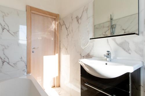un bagno bianco con lavandino e doccia di ClubHotel Residence Cesenatico a Cesenatico