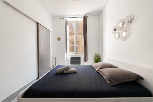 - une chambre avec un lit noir et une fenêtre dans l'établissement Appartement central confortable et spacieux, à Carcassonne