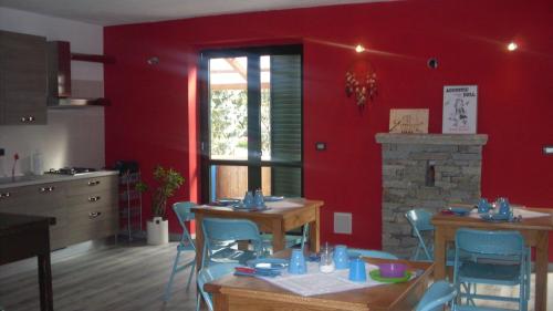 kuchnia z czerwonymi ścianami oraz stołem i krzesłami w obiekcie B&B Valle Orco w mieście Sparone
