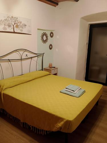 a bedroom with a bed with a yellow blanket at Casa Emma in Cremolino
