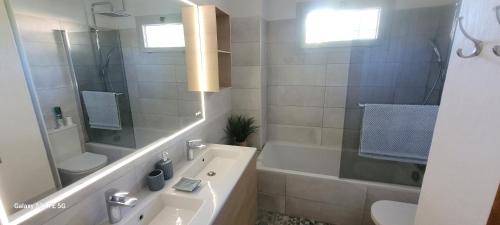 a bathroom with a tub and a toilet and a sink at Bastide avec grande piscine face à Sainte Victoire in Rousset