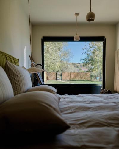 a bedroom with a bed and a large window at 99 Maison by Noire - Deluxe Bungalow Sibiu -Adults Only in Sibiu