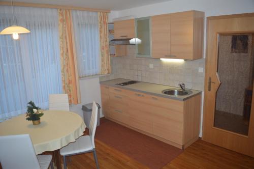 a kitchen with a table and a sink and a table and chairs at Apartment Jakelj in Kranjska Gora
