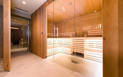 - un sauna avec des murs en bois et des parois en verre dans l'établissement Posthotel Lechtal, à Holzgau