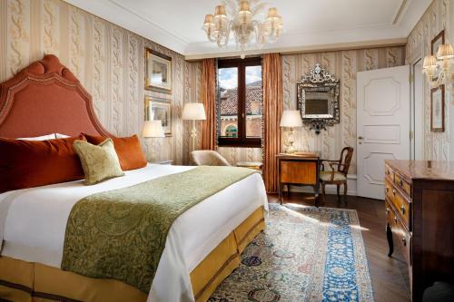 a bedroom with a large bed and a chandelier at The Gritti Palace, a Luxury Collection Hotel, Venice in Venice