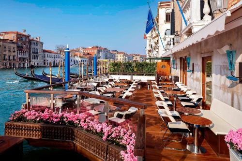 a balcony with tables and chairs next to the water at The Gritti Palace, a Luxury Collection Hotel, Venice in Venice