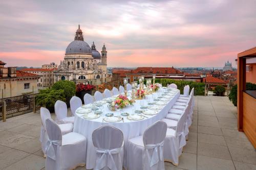 a long table with white tables and chairs on a roof at The Gritti Palace, a Luxury Collection Hotel, Venice in Venice