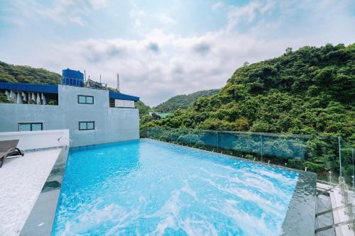 a swimming pool on top of a building with a mountain at Sand Hotel in Cat Ba