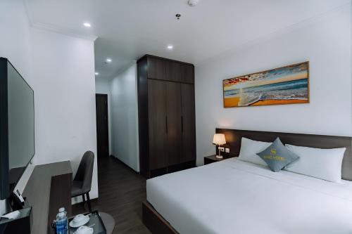 a bedroom with a bed and a desk and a television at Sand Hotel in Cat Ba