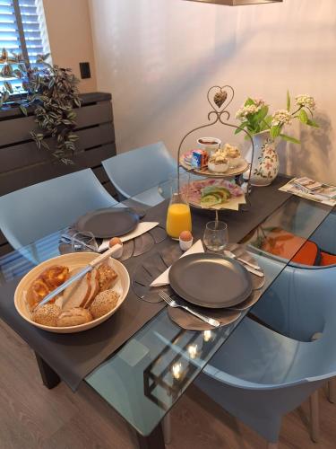 een glazen tafel met eten erop bij B&B om de hoek in Oostburg