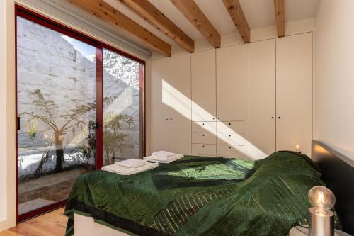 a bedroom with a bed and a large window at Almoxarife Beach House in Praia do Almoxarife