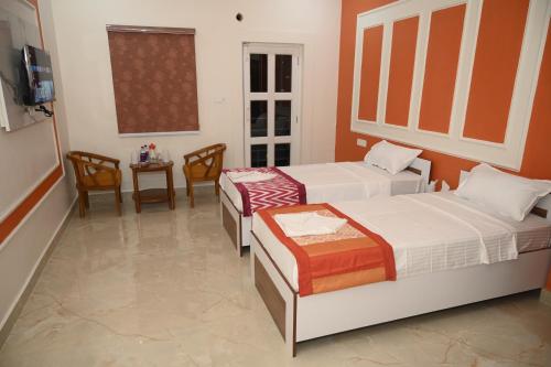 a bedroom with two beds and a table and a tv at shangrila stay in Bodh Gaya