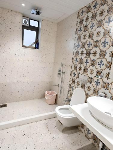 a bathroom with a toilet and a sink and a tub at Mizzle Exotica Lonavala in Lonavala