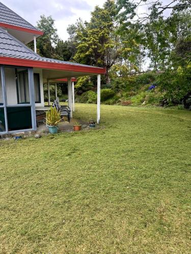 a house with a lawn in front of it at RUs Terraces in Kauri