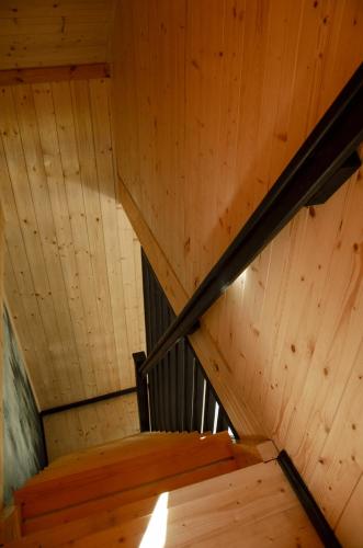 a staircase in a wooden cabin with a wooden ceiling at Dom na krańcu lasu in Ostrowy