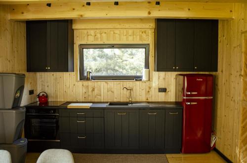 a kitchen with a red refrigerator and a window at Dom na krańcu lasu in Ostrowy