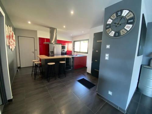 a large clock on a wall in a kitchen at Magnifique villa avec piscine, Jacuzzi et Baignoire Balnéo in Upie