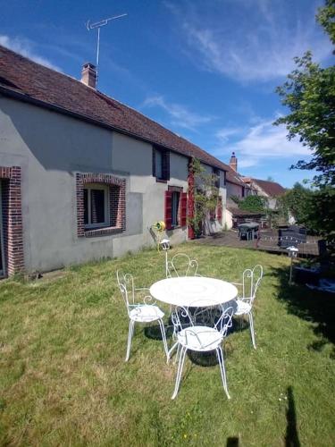 - une table et des chaises dans la cour d'une maison dans l'établissement Maison de campagne familiale, à Villefranche-Saint-Phal
