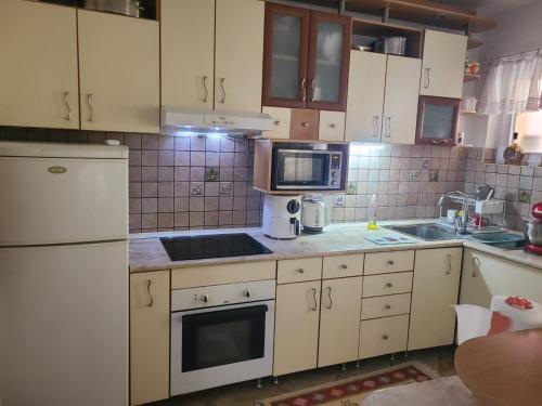 a kitchen with white cabinets and a white appliances at Ace in Vodno