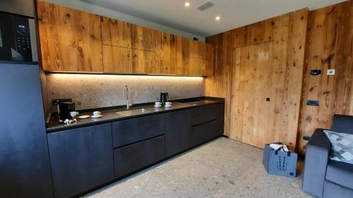 a kitchen with a sink and wooden walls at Il giardino di Anna - Appartamento 2 in Fai della Paganella