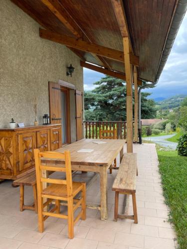 une table et des chaises en bois sur une terrasse dans l'établissement Rez de villa entre ville et montagne, à Brié-et-Angonnes