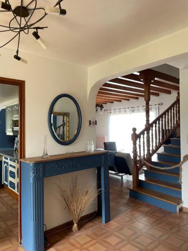 un salon avec une cheminée bleue et un escalier dans l'établissement Rez de villa entre ville et montagne, à Brié-et-Angonnes