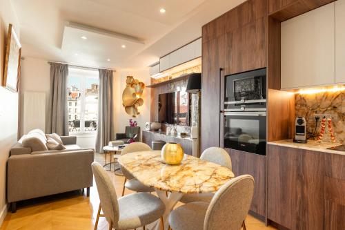 une cuisine et un salon avec une table et des chaises dans l'établissement SaintGermainByCecile - Luxueux 4 pièces AC Perle, à Paris