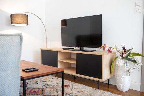 - un salon avec une télévision sur un centre de divertissement en bois dans l'établissement Suite Très Moderne et Cosy, Proche Centre-ville, MULHOUSE CENTRE, à Mulhouse