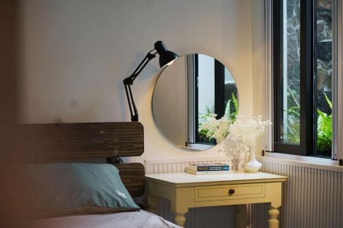 a bedroom with a mirror and a table with a bed at Thỏ Non Garden - Bảo Lộc Center #3BR in Bao Loc
